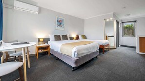 A hotel room with a bed, bedside tables, a desk, and a chair. - Comfort Inn The Pier (George Town)