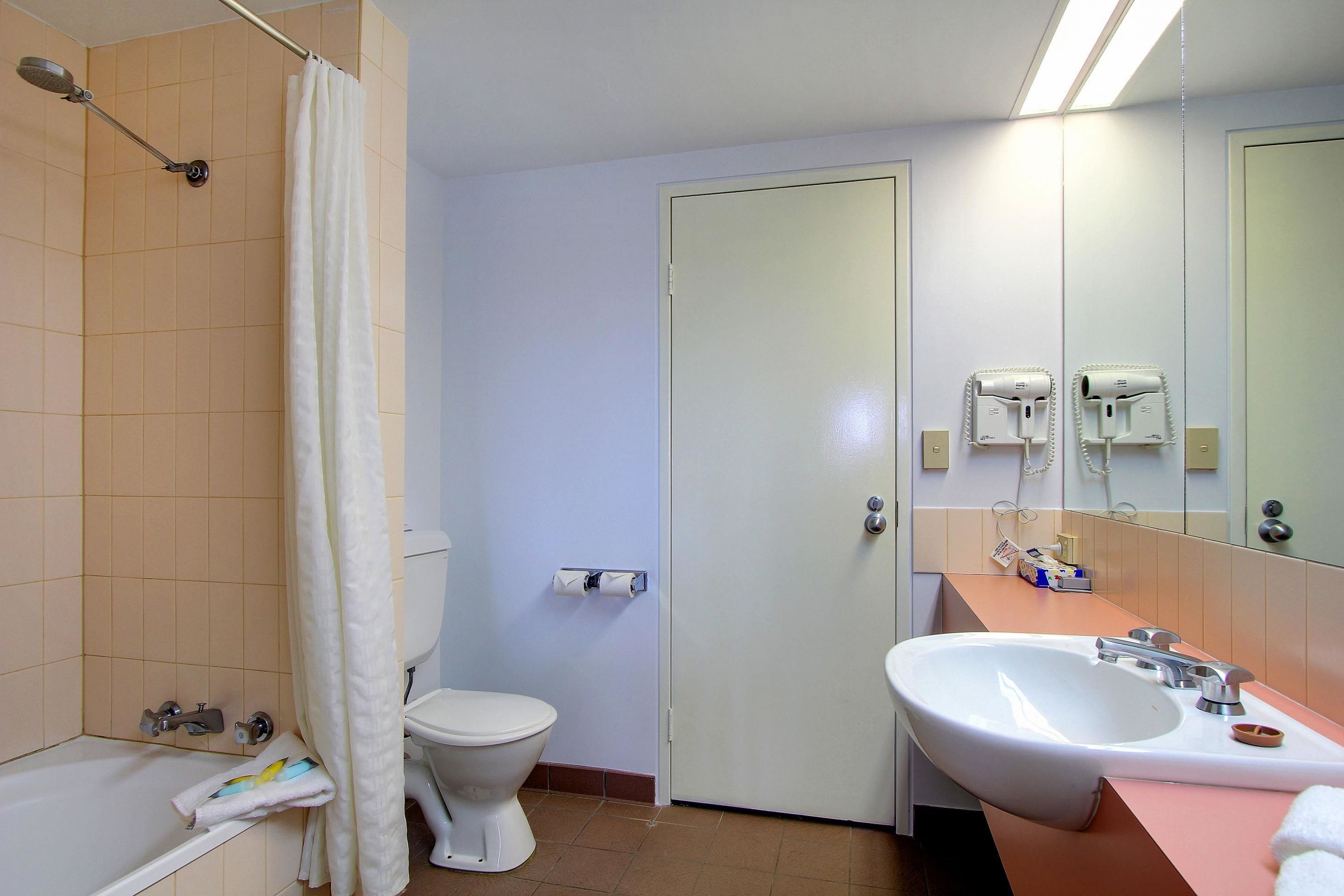 Un baño con bañera, inodoro, lavabo y cortina de ducha.