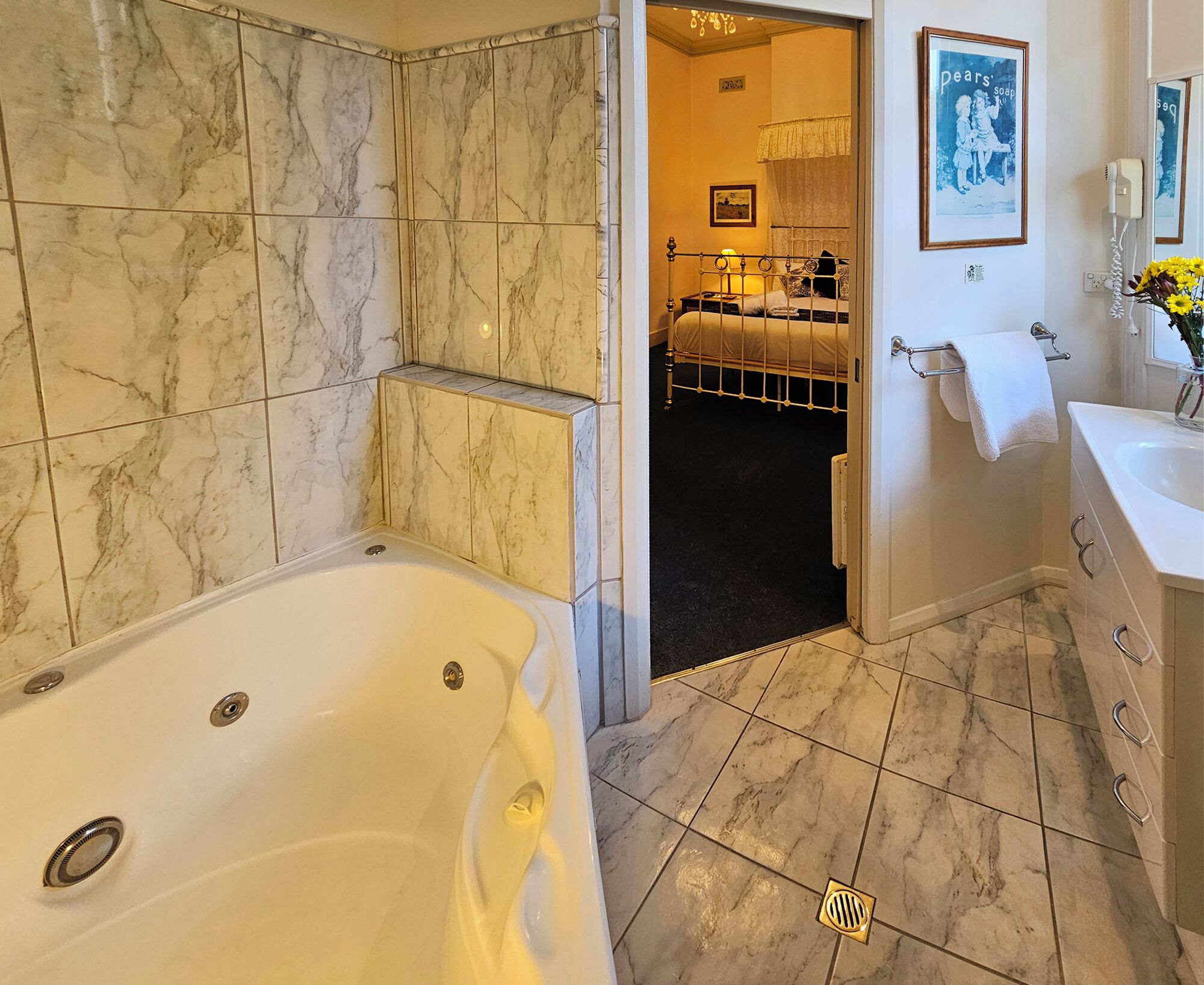 A bathroom with a bathtub, a shower area, and a sink.