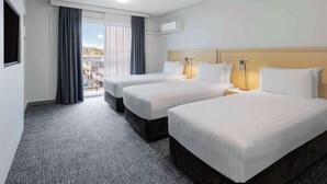 A hotel room with two beds, a large window with curtains, a ceiling light, and a view of the city. - Best Western Hobart (Hobart)