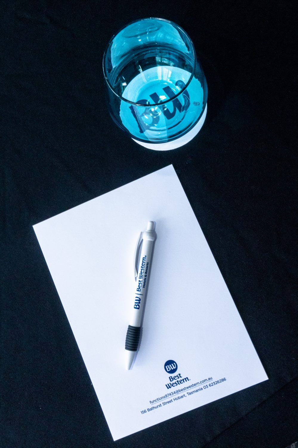 Un stylo sur une feuille de papier blanche, avec le logo « Best Western » et les coordonnées.