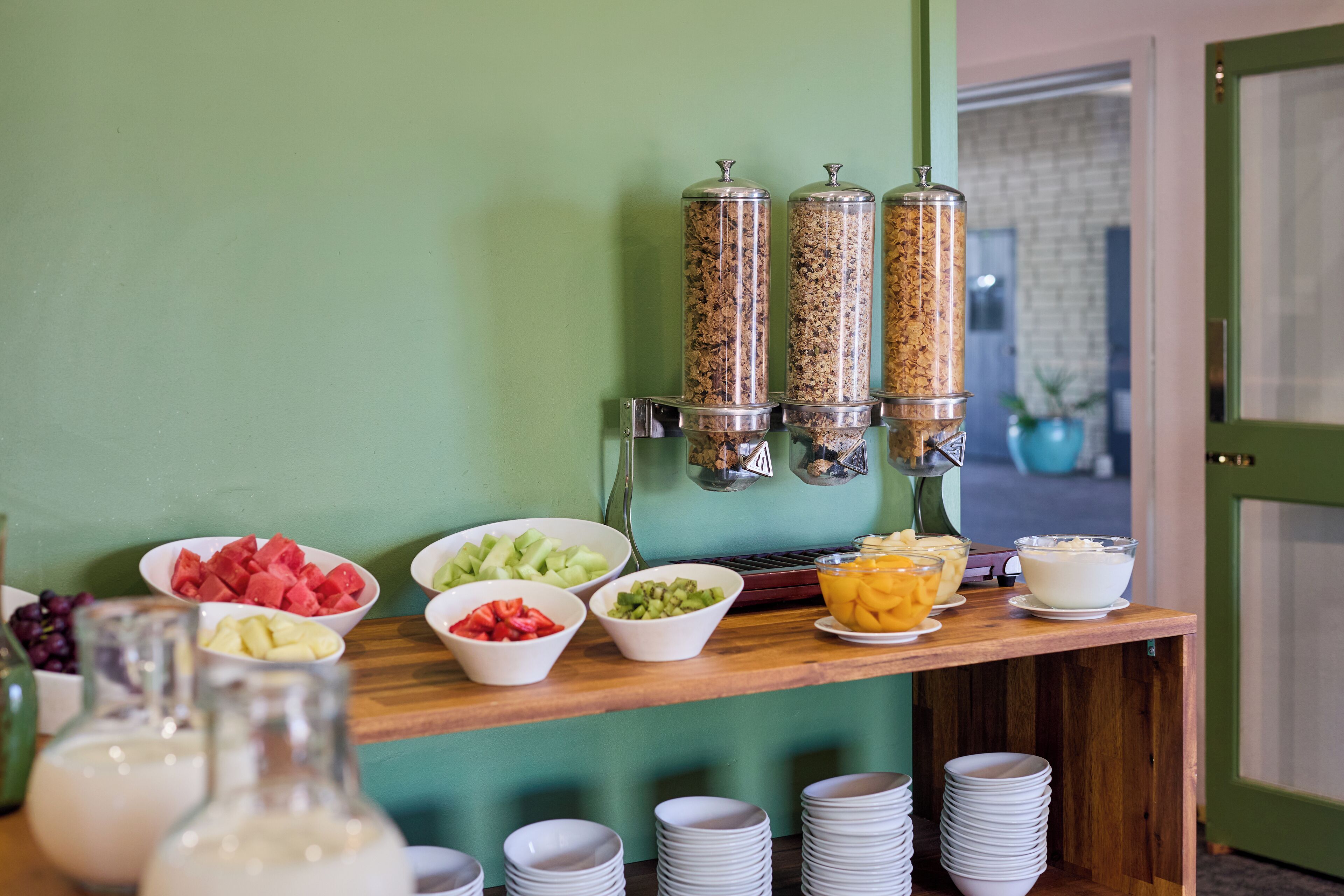 A buffet setup with various food items and drink dispensers.
