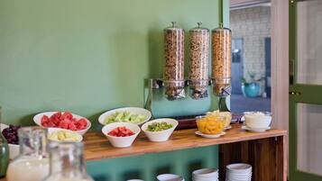 Una mesa de buffet con diversas opciones de comida y dispensadores de bebidas.