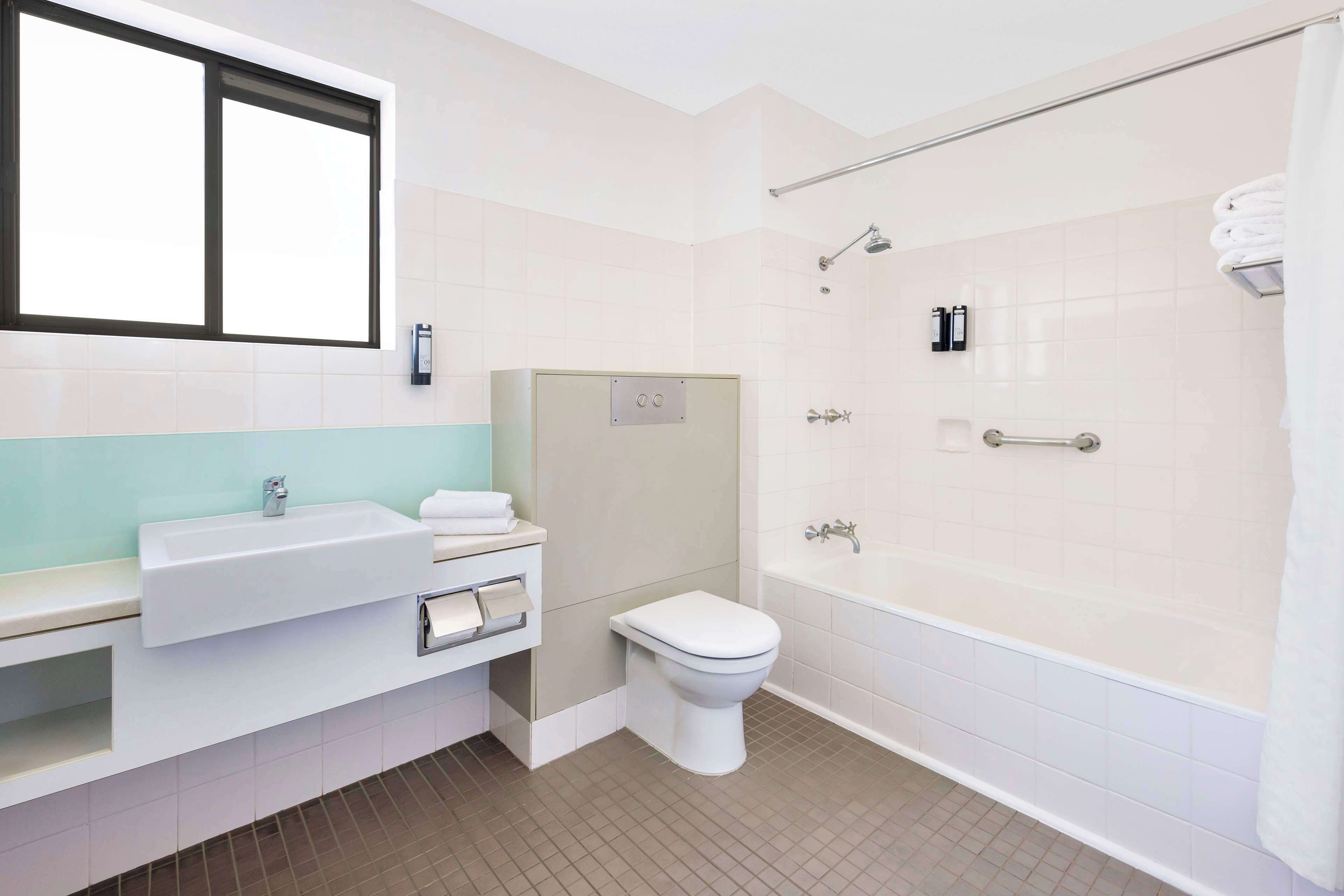Un baño moderno con lavamanos, inodoro y bañera.