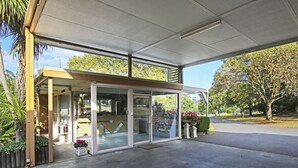 A modern building with a covered entrance, glass doors, and a reception area. - Moe Parklands Motel (Newborough)