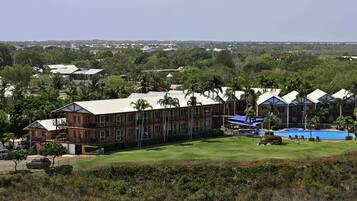 A resort with multiple buildings, a swimming pool, and a well-maintained lawn.