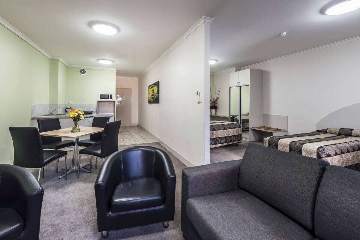Una habitación moderna con comedor, kitchenette, sofá y cama.