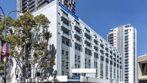 A multi-story hotel with a prominent Comfort Inn & Suites sign, featuring a modern architectural design with balconies and a clear view of the surrounding urban environment. - Comfort Inn & Suites Goodearth Perth (Perth)