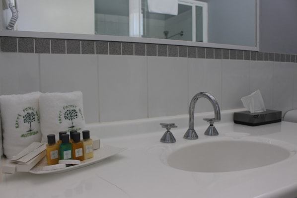 A bathroom with a sink, mirror, and toiletries. - Karri Forest Motel (Pemberton)