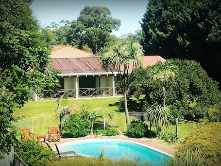 Una piscina al aire libre, sillones reclinables de piscina. Karri Forest Motel