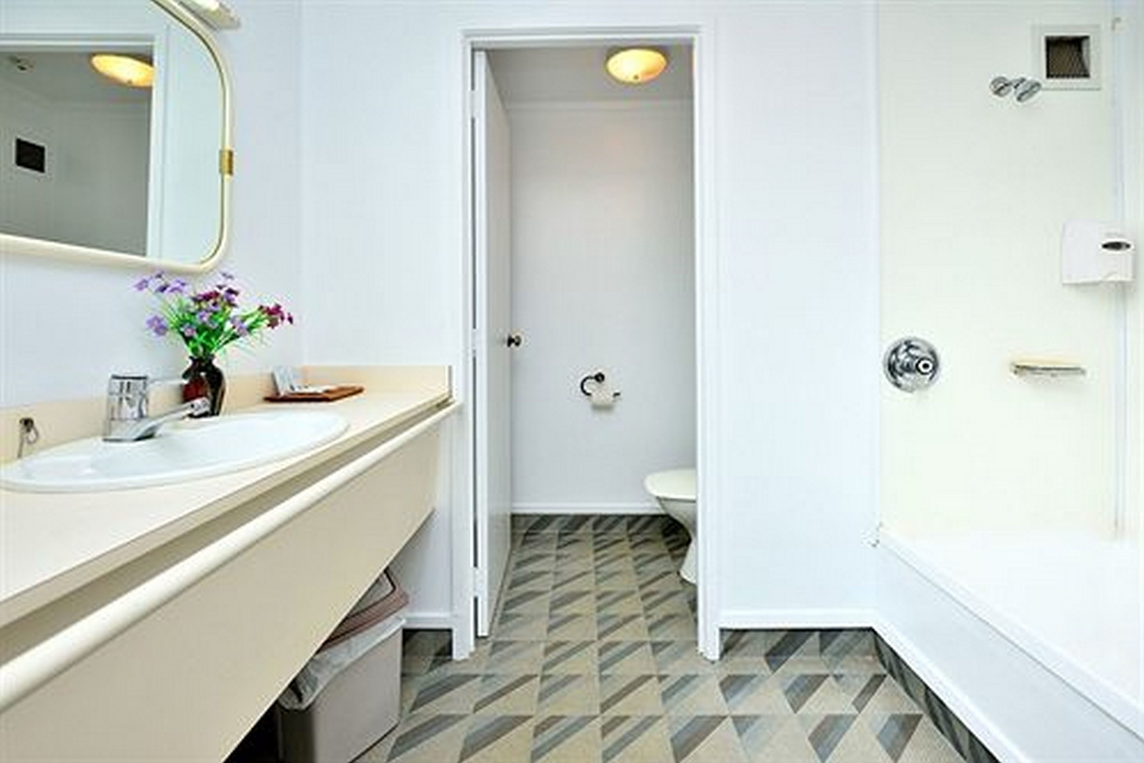 Ein Badezimmer mit Waschbecken, Spiegel und Toilette.