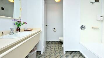 Ein Badezimmer mit Waschbecken, Spiegel und Toilette.