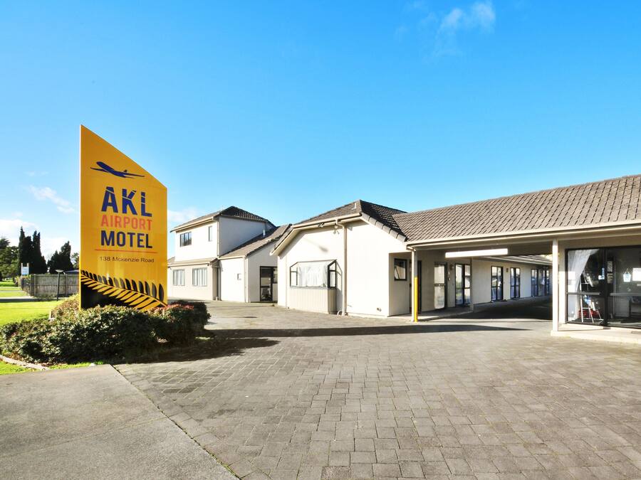 A building with a sign reading "AKL Airport Motel 138 McKenzie Road".