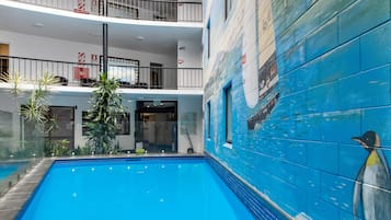 Swim surrounded by a nautical-themed mural and lush greenery.