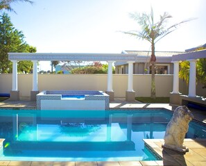Una piscina al aire libre, una piscina climatizada, tumbonas