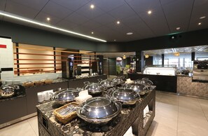 Ein reichhaltiges Buffet mit mehreren Servierstationen, einer Küchenzeile und einem Sitzbereich mit einer Theke.
