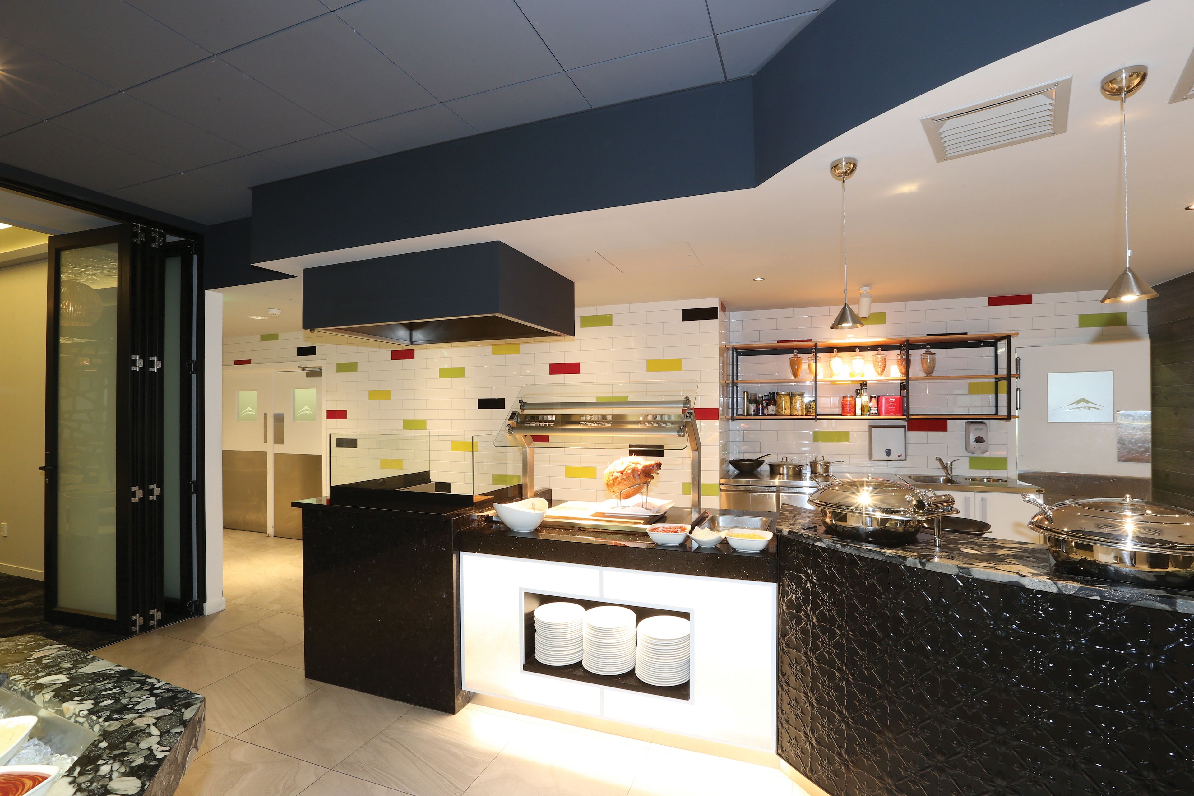 A modern kitchen with a central island, a built-in oven, and a variety of kitchen appliances.