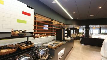 A buffet area with various food items and serving utensils.