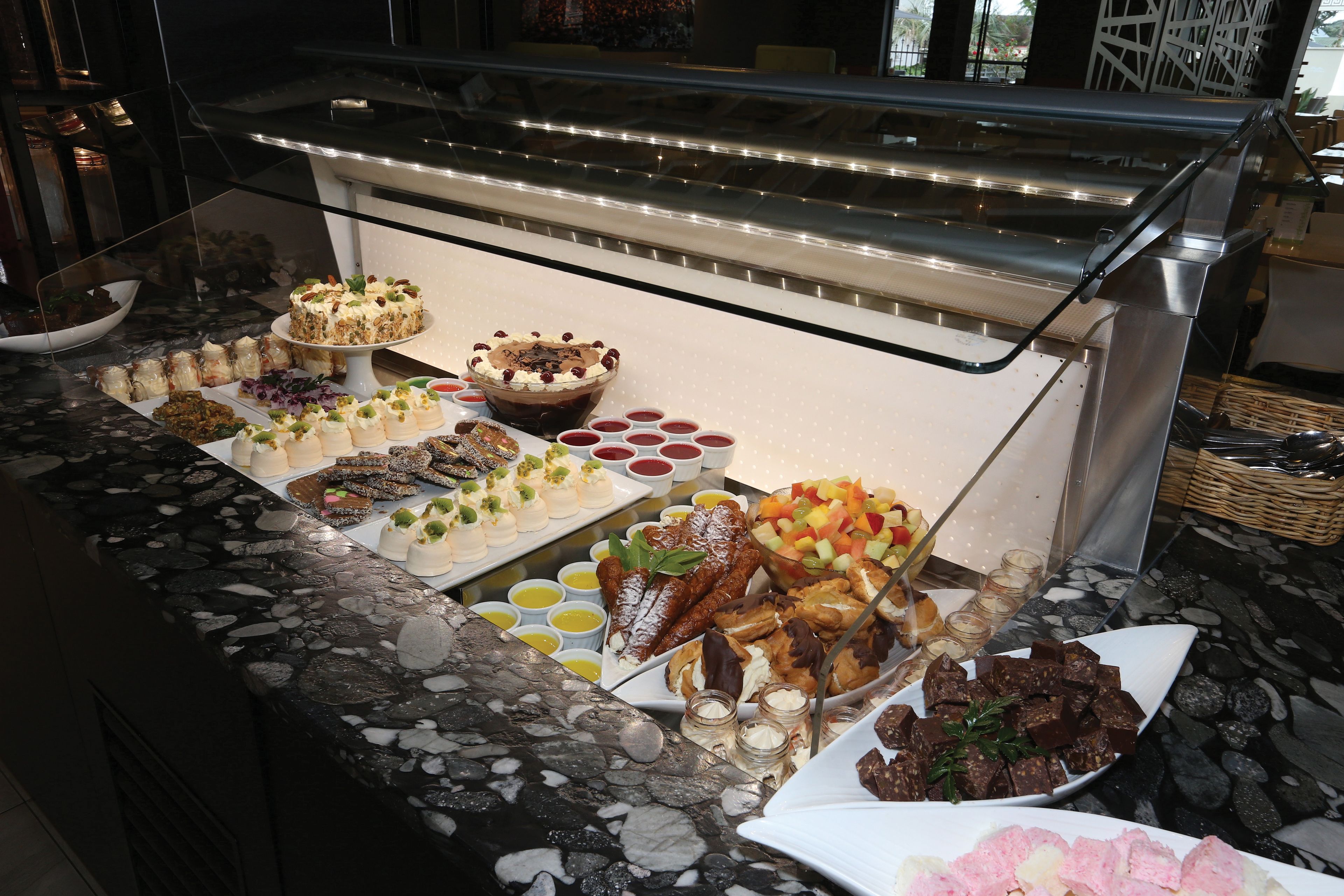 A buffet with various food items and a glass display case.