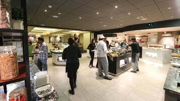 Un espace buffet avec plusieurs stands de nourriture où les clients se servent eux-mêmes.