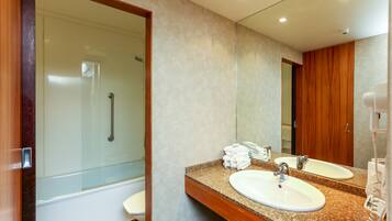 Une salle de bain moderne avec deux vasques, une douche en verre et un meuble-lavabo en bois.
