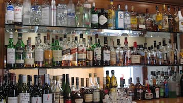 A bar with multiple shelves stocked with various liquor bottles.