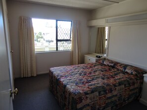 Escritorio, cortinas opacas, tabla de planchar con plancha