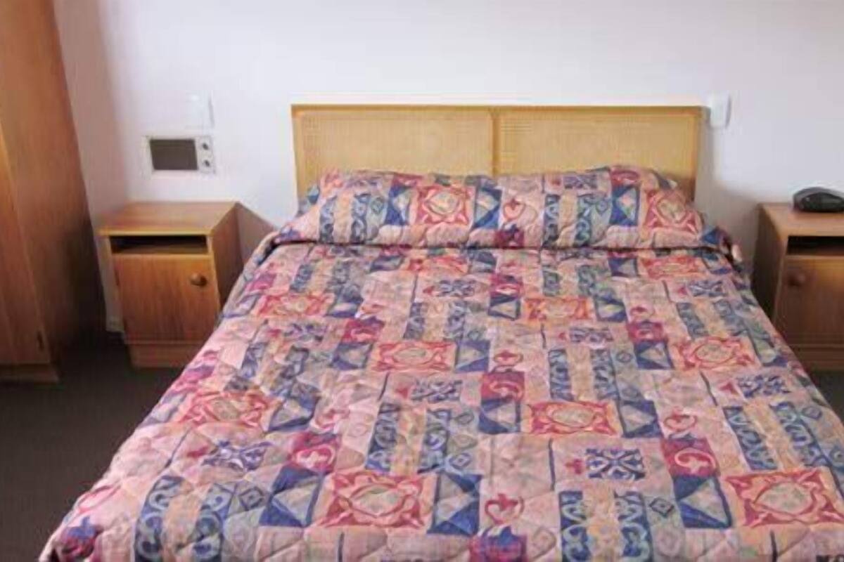 Escritorio, cortinas blackout y tabla de planchar con plancha