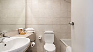 Un baño moderno con lavabo, inodoro y bañera.