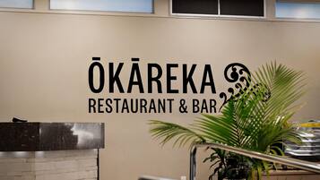 A wall with the sign 'ÖKAREKA RESTAURANT & BAR' indicating the establishment's name.