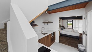 Quarto de hotel compacto com cozinha compacta, uma cama e vista para o exterior.