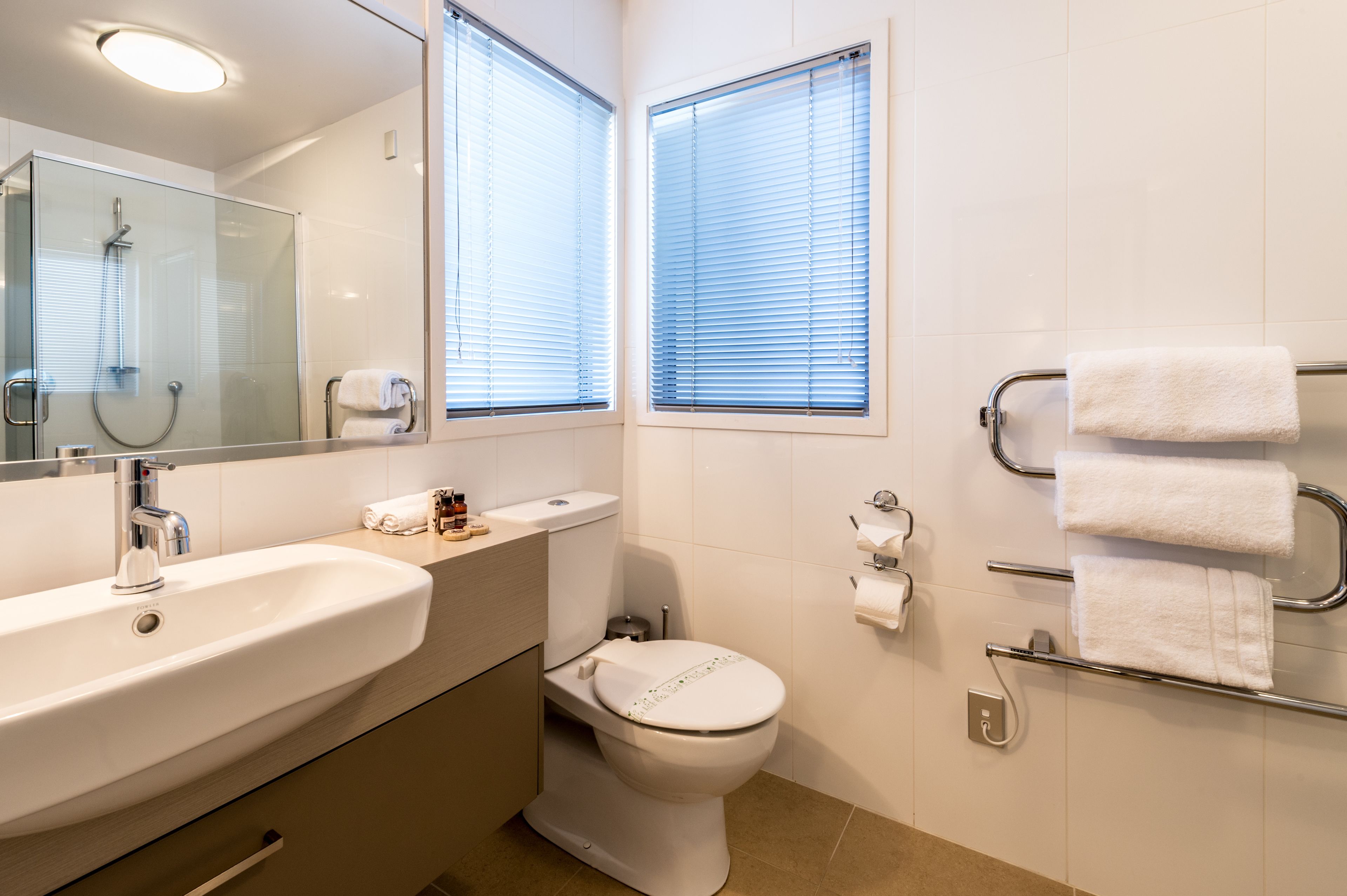 A modern bathroom with a sink, toilet, and shower.