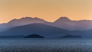 A mountain range with a calm sea in the foreground.
