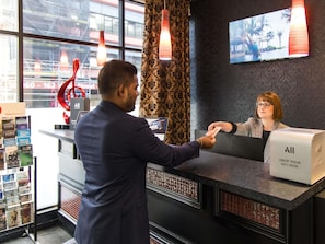 A hotel reception desk with a digital screen, a cash register, and a drop key for keys. - Mercure Wellington Abel Tasman (Wellington)