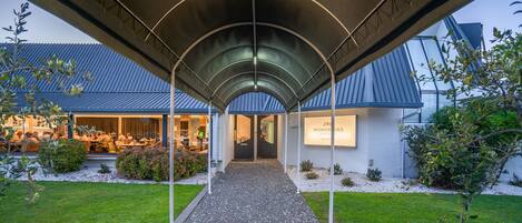 A covered walkway leading to a restaurant with a modern architectural design.