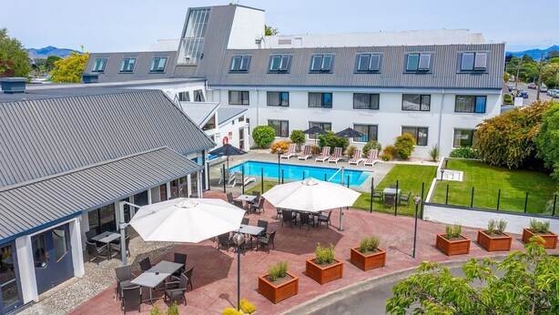 Un hôtel doté d’une piscine, d’un espace extérieur aménagé et offrant une vue sur les montagnes.