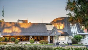 Un bâtiment moderne doté d’un toit en pente, d’une entrée couverte et d’une enseigne indiquant la présence d’un restaurant et d’un bar.
