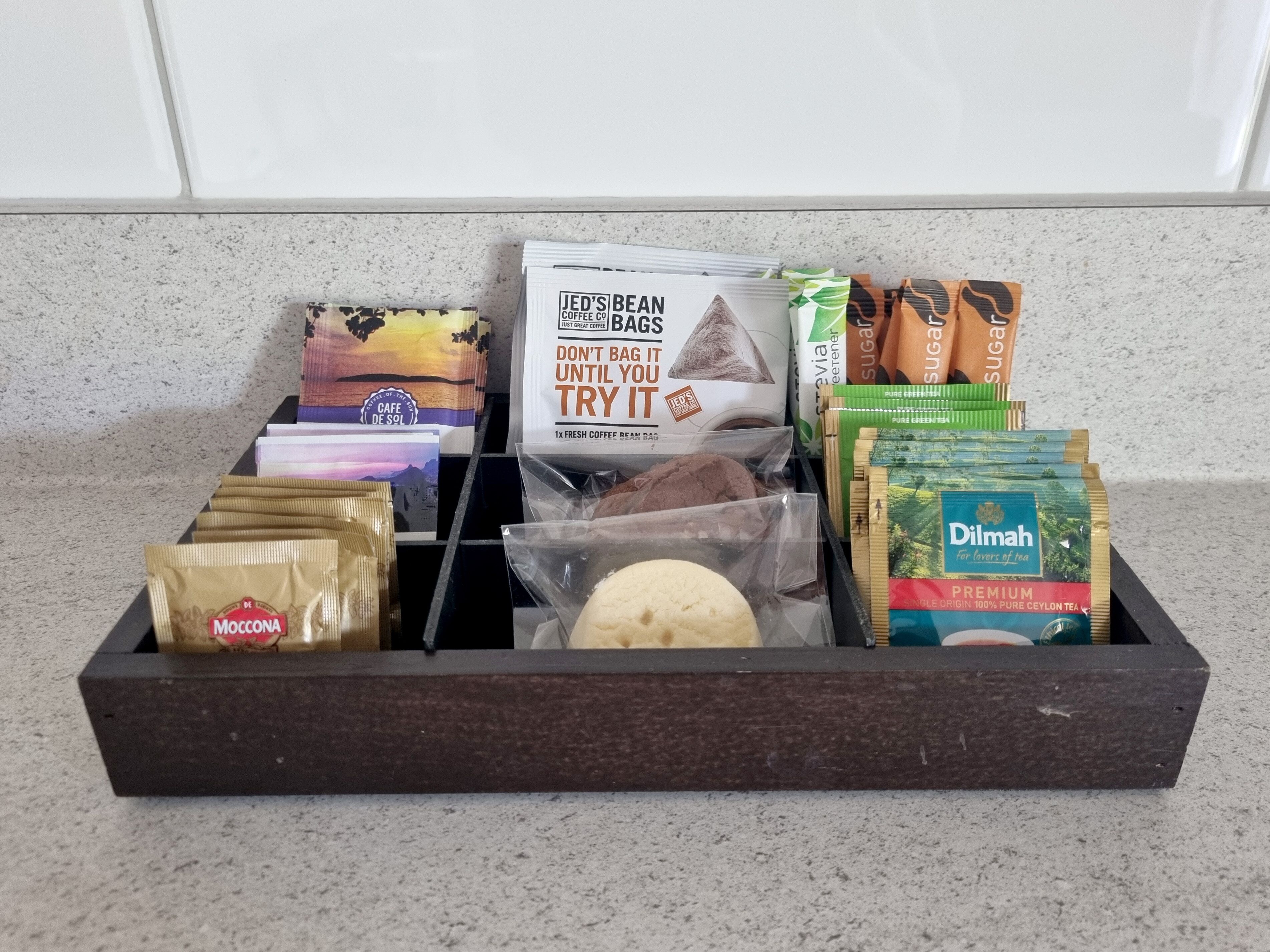 A tray with various coffee and tea products including JED'S BEAN, Moccona, and Dilmah tea.