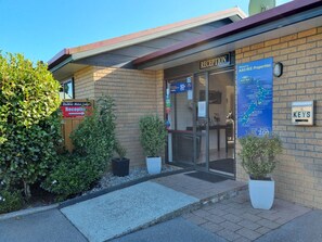 A reception area with a sign for Gables Motor Lodge, a reception desk, and a KEYS mailbox.