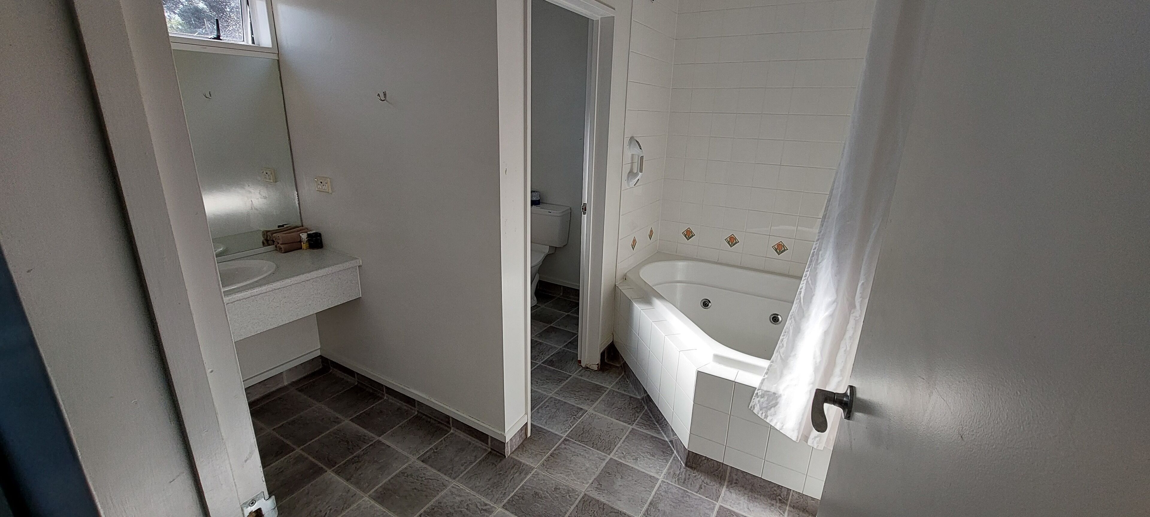 A bathroom with a bathtub, toilet, and a sink.