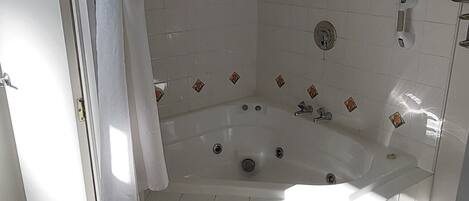 A bathroom with a bathtub, a shower, and a toilet.