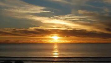 A sunset over a calm sea with a clear horizon.