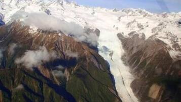 Un glacier, avec un paysage montagneux accidenté en arrière-plan.