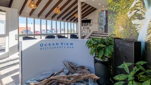 A reception desk at Ocean View Restaurant & Bar with a view of parked cars outside. - Beachfront Hotel (Hokitika)