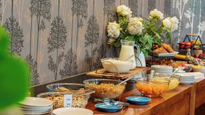 A buffet table with various food items and a milk jug. - The Beachcomber Hotel (Nelson)