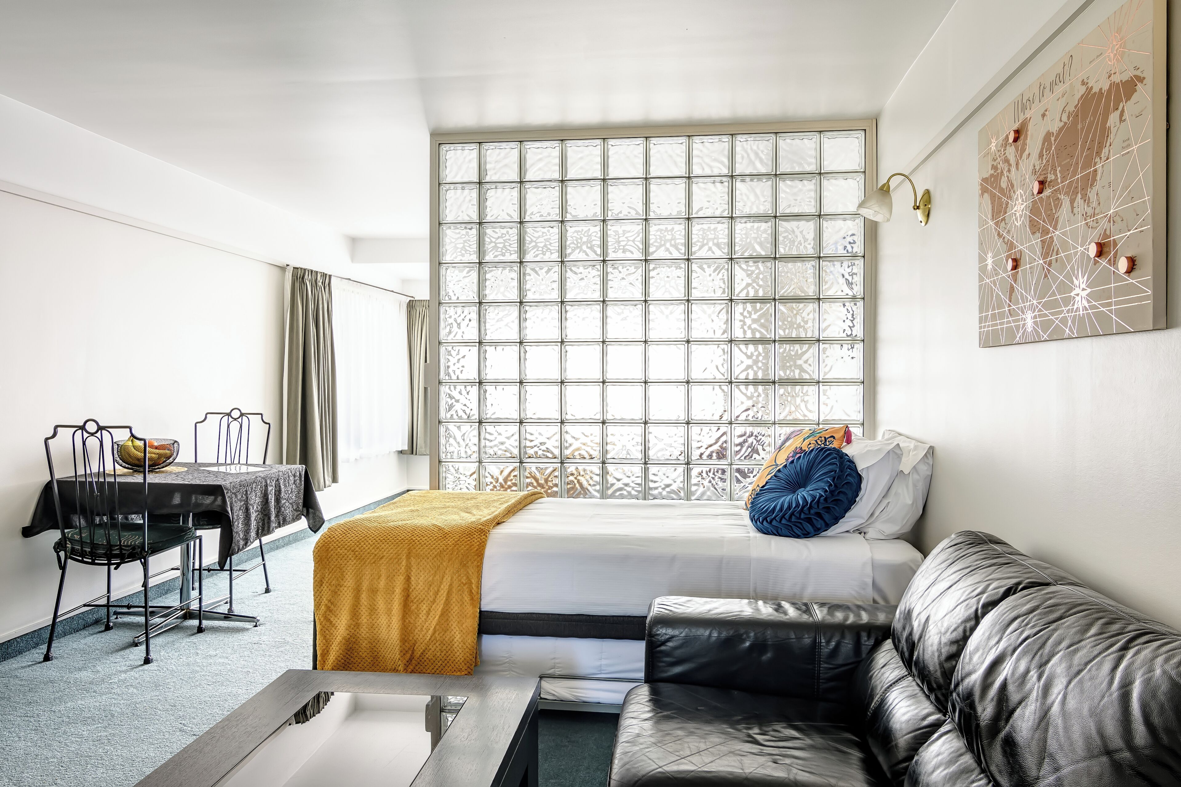 Una habitación con cama, sofá, mesa de comedor y ventana con vistas.