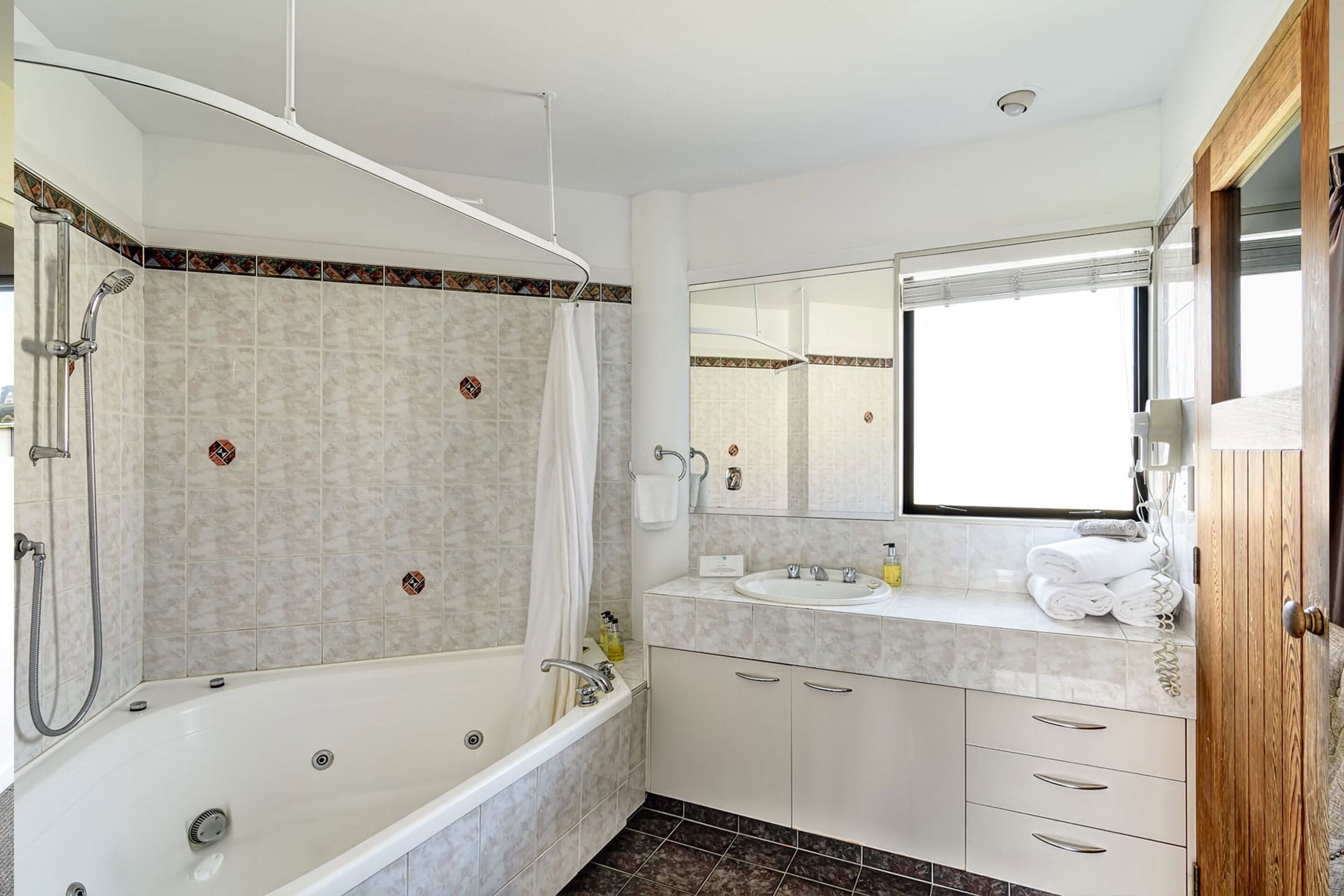 A modern bathroom with a bathtub, shower, and sink.