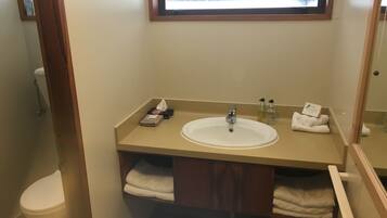 Un baño con lavabo, espejo y perchero para toallas.