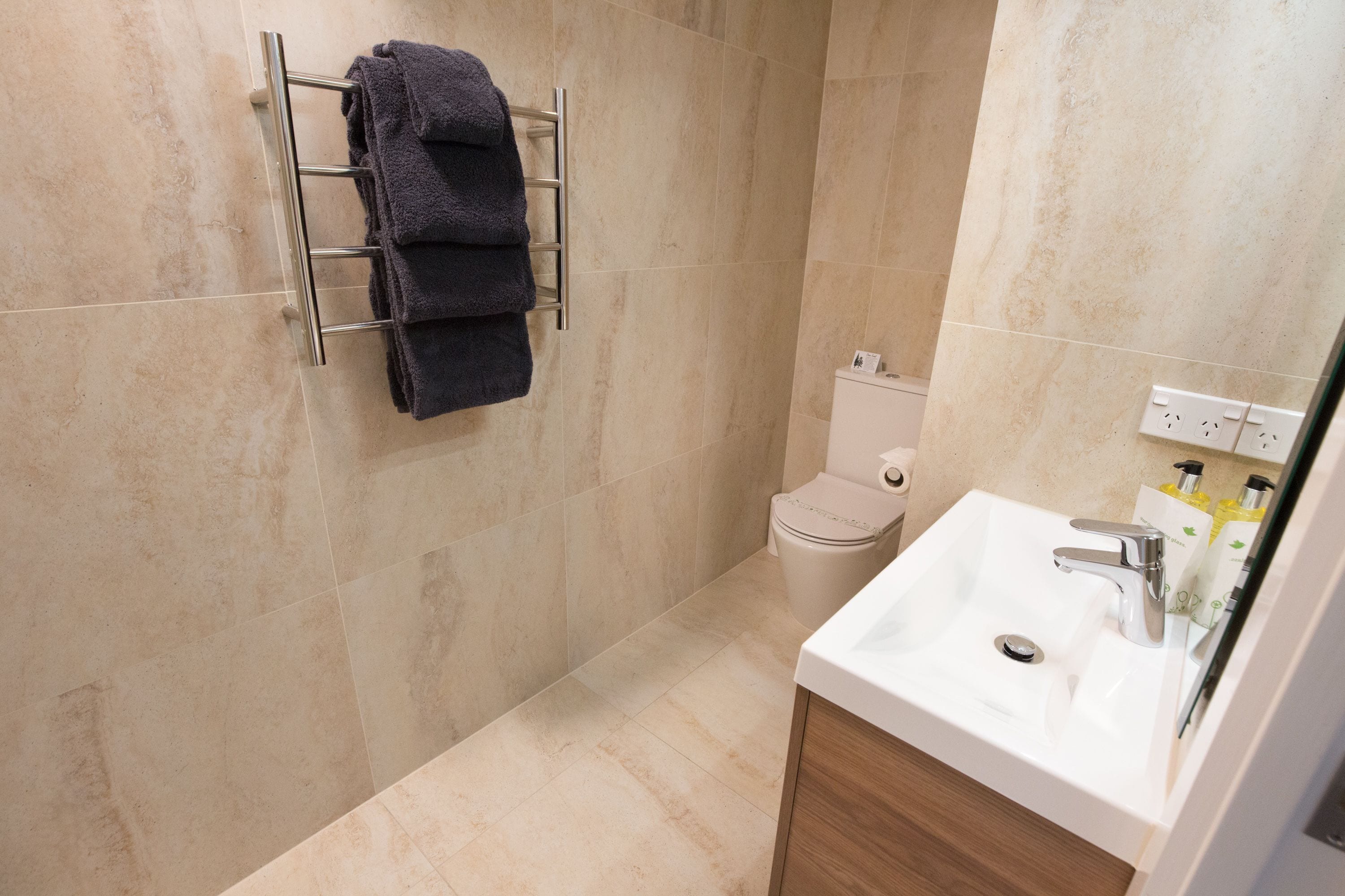 A bathroom with a toilet, sink, and towel rack.
