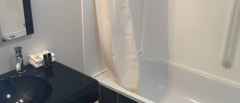 Een moderne badkamer met een zwart wastafel, een witte handdoek en een douchecabine van glas.